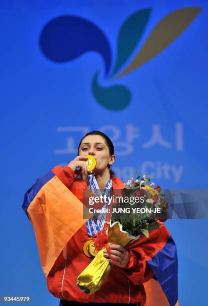 Nazik Avdalyan of Armenia kisses her gold medal on the podium following the women's 69kg category event at the World Weightlifting Championships in...