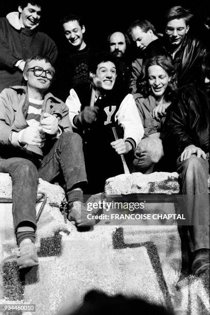West-Berliner sit and start hammering on the Berlin Wall on November 9, 1989 to ask for its fall. - After months of mass protests against regime and...