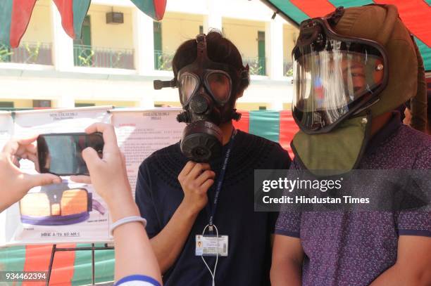 Boys trying masks of Indian Army during exhibition of Weapon and Equipment for public at under Headquarters Bengal Area at St. Xavier's College, Park...