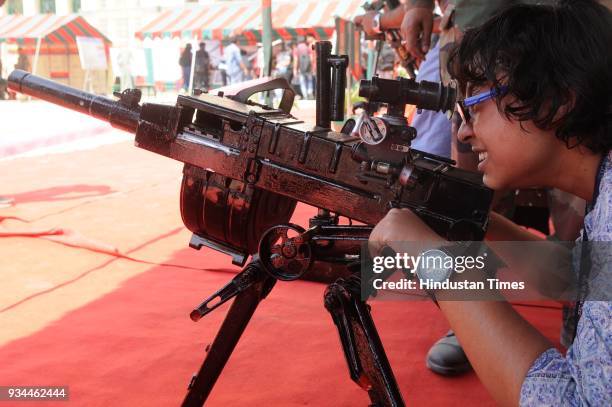 Girl checking machine gun during exhibition of Weapon and Equipment for public at under Headquarters Bengal Area at St. Xavier's College, Park Street...