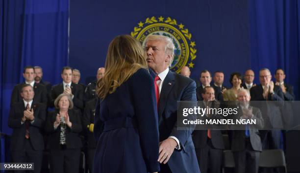 President Donald Trump kisses First Lady Melania Trump as he arrives to speak about combating the opioid crisis, at Manchester Community College in...