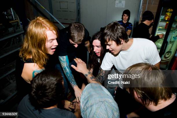 The members of Underoath, Aaron Gillespie, Grant Brandell, Spencer Chamberlain, James Smith, Christopher Dudley and Timothy McTague, do a group hand...