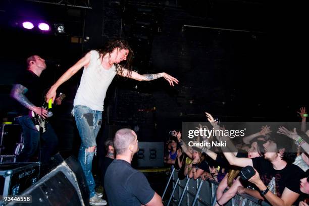 Spencer Chamberlain of Underoath performs standing on the front of the stage, pointing at cheering fans in the front row of the audience at Estragon...