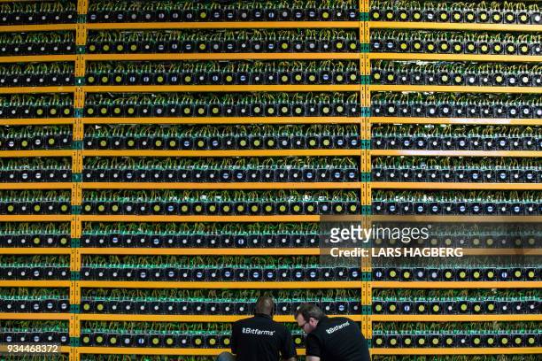 Two technicians inspect bitcon mining at Bitfarms in Saint Hyacinthe, Quebecon March 19, 2018. - Bitcoin is a cryptocurrency and worldwide payment...