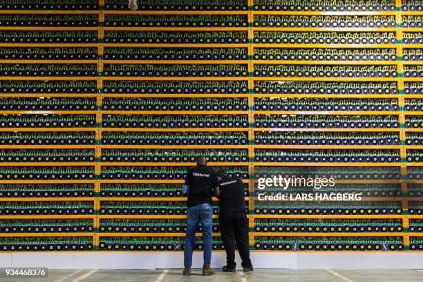 Two technicians inspect bitcon mining at Bitfarms in Saint Hyacinthe, Quebecon March 19, 2018. - Bitcoin is a cryptocurrency and worldwide payment...