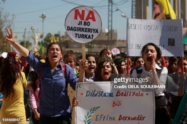 Syrian Kurds hold placards reading "No to the Turkish occupation" as they take part in a protest in the northeastern city of Amude, against the...