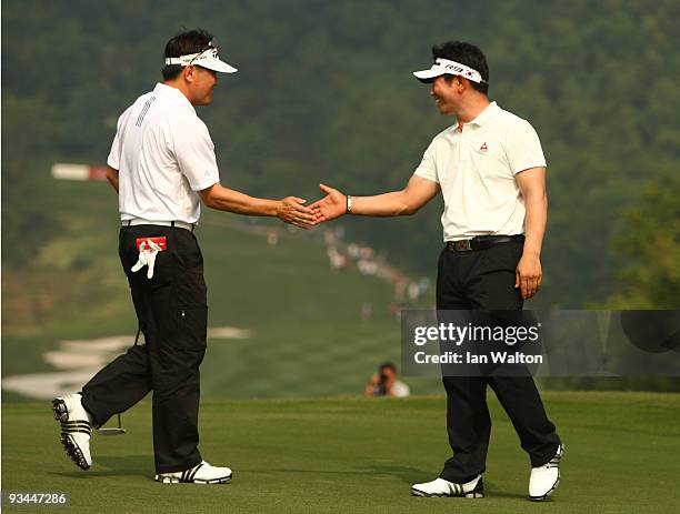 Yong-eun Yang and Charlie Wi of Korea celebrate during the Foursomes on the second day of the Omega Mission Hills World Cup on the Olazabal course on...