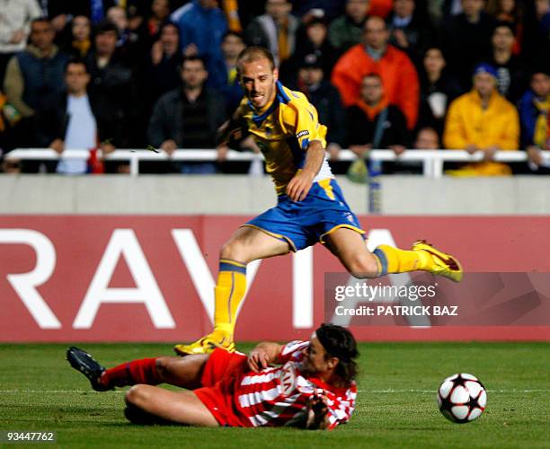 Apoel Nicosia's Nectarios Alexandrou jumps over Atletico Madrid's Tomas Ujfalusi during their UEFA Champions League group D football match at the GSP...