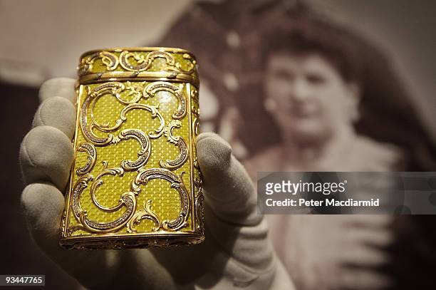 Faberge Imperial enamel cigarette case is displayed in front of a photograph showing Her Imperial Highness Maria Pavlovna, Grand Duchess Vladimir at...