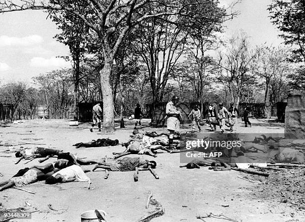 Soldiers remove the bodies in a mass grave which will be set on fire to prevent disease after a savage revenge raid by Senga villagers on members of...