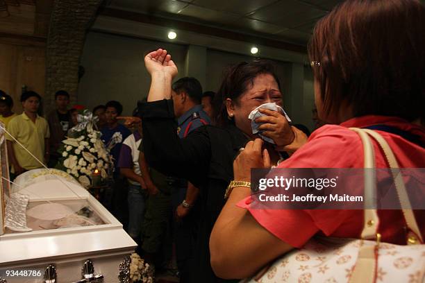 Relative of a journalist who was among the 57 people massacred in the southern Philippine town of Ampatuan in Maguindanao this week, weeps at a wake...