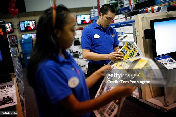 Best Buy employees study the sale ad before the store store opens on November 27, 2009 in Fort Worth, Texas. According to the National Retail...