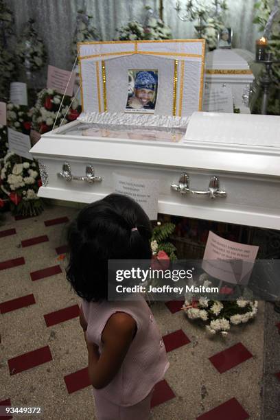 Child looks into a coffin of a journalist among the 57 people massacred in the southern Philippine town of Ampatuan in Maguindanao at a wake held for...