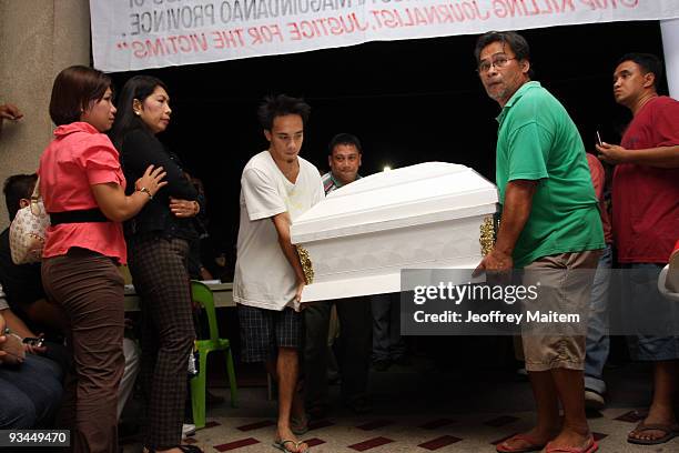 Relatives arrange the coffin of a slain journalist, massacred in the southern Philippine town of Ampatuan in Maguindanao, during a wake held for the...