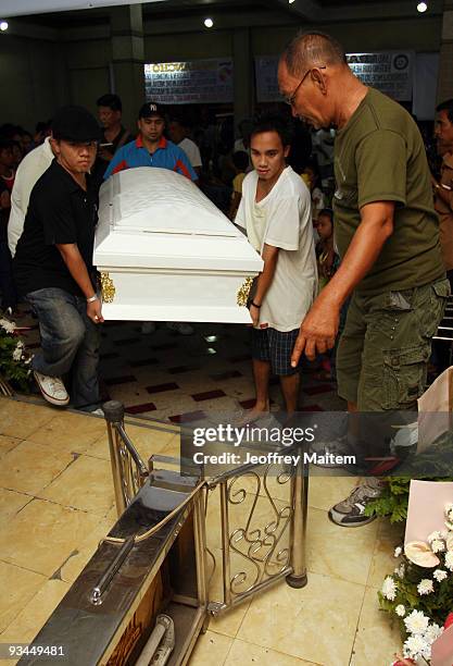 Relatives arrange the coffin of a slain journalist, massacred in the southern Philippine town of Ampatuan in Maguindanao, during a wake held for the...
