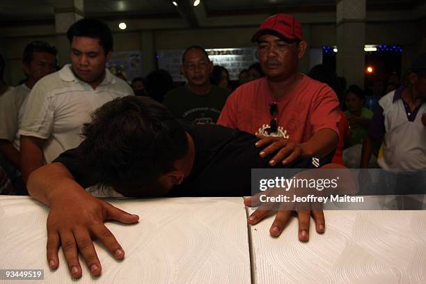 Son of journalist Maritess Cablitas, one of 57 people massacred in the southern Philippine town of Ampatuan in Maguindanao this week, weeps at a wake...
