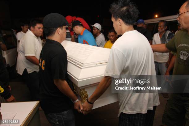 Relatives arrange the coffin of a slain journalist massacred in the southern Philippine town of Ampatuan in Maguindanao, during a wake held for the...