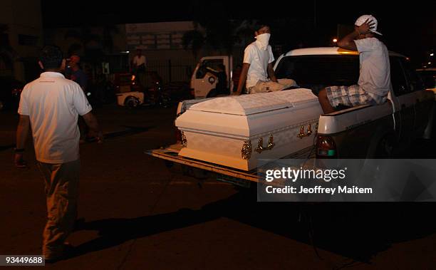Relatives prepare to unload a coffin of a slain journalist, massacred in the southern Philippine town of Ampatuan in Maguindanao, during a wake held...