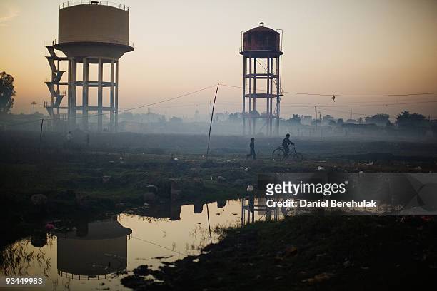 Children play near water towers in front of their homes near the Union Carbide factory on November 27, 2009 in Bhopal, India. Twenty-five years after...