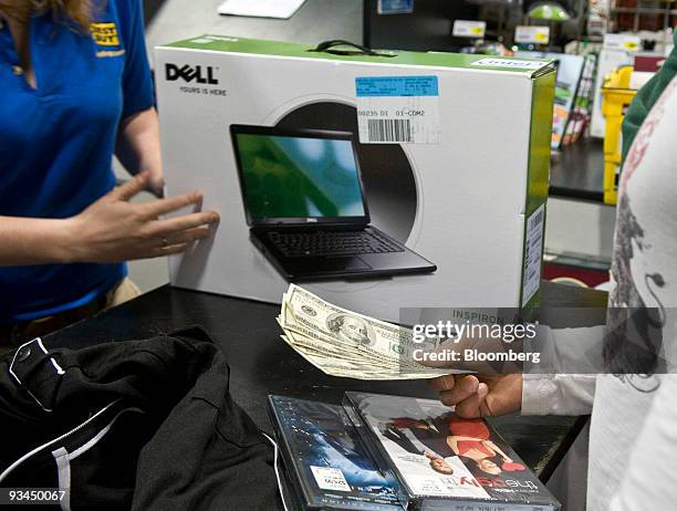 Shopper pays cash for a Dell computer and some DVDs at the Best Buy store in Corpus Christi, Texas, U.S., on on Friday, Nov. 27, 2009. Shoppers...