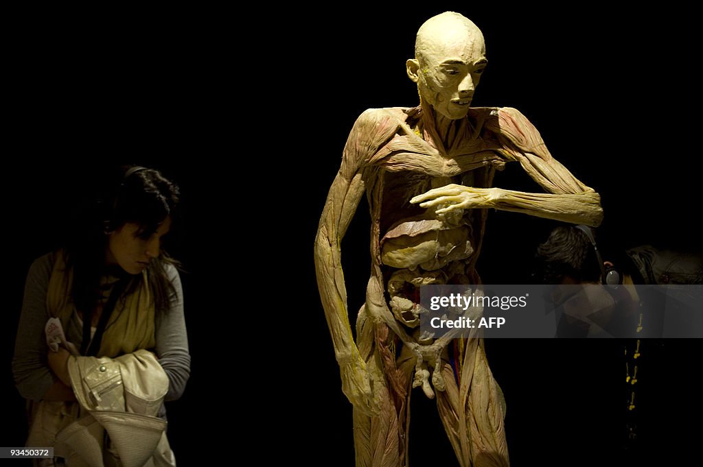 Visitors look at a body on display at th