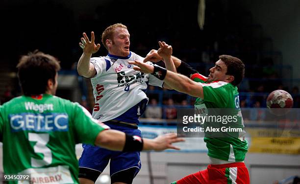 Stefan Kneer of Grosswallstadt is challenged by Bennet Wiegert and Bartosz Jurecki of Magdeburg during the Toyota Handball Bundesliga match between...