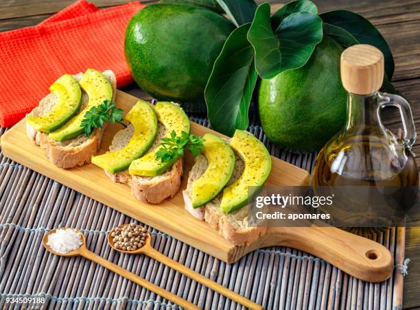 snack or appetizer of avocado slices bruschetta with olive oil, peppermint and salt - avocado oil stock pictures, royalty-free photos & images
