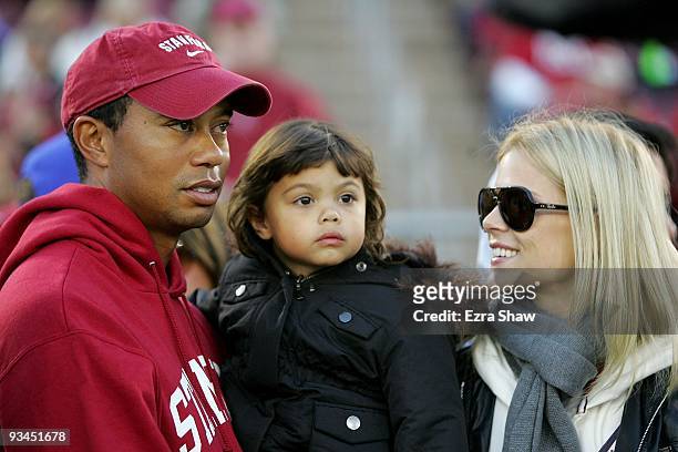 Honorary Standford Cardinal captain Tiger Woods holds his daugher, Sam, and speaks to his wife, Elin Nordegren, on the sidelines before the Cardinal...