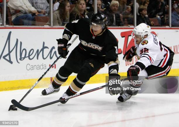 Teemu Selanne of the Anaheim Ducks is pursued by Kris Versteeg of the Chicago Blackhawks for the puck in the first period at the Honda Center on...