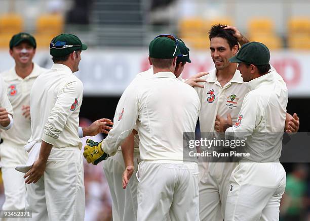 Mitchell Johnson is congratulated by teammates after claiming the wicket of Denesh Ramdin of the West Indies during day three of the First Test match...