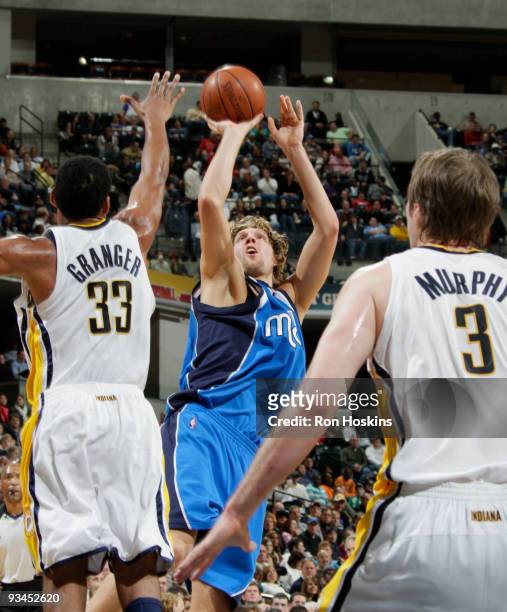 Dirk Nowitzki of the Dallas Mavericks shoots over Danny Granger and Troy Murphy of the Indiana Pacers at Conseco Fieldhouse on November 27, 2009 in...