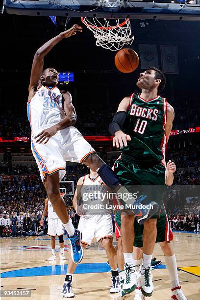 Kevin Durant of the Oklahoma City Thunder finishes a dunk on Carlos Delfino of the Milwaukee Bucks on November 27, 2009 at the Ford Center in...