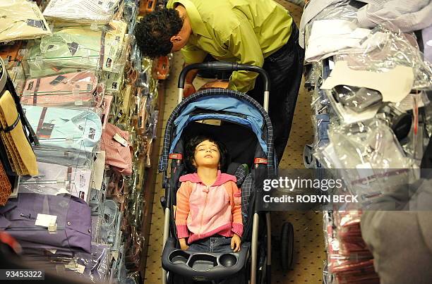 Girl sleeps as her father shops for Black Friday bargains at the Glendale Galleria shopping mall in Glendale, California on November 27, 2009. The...