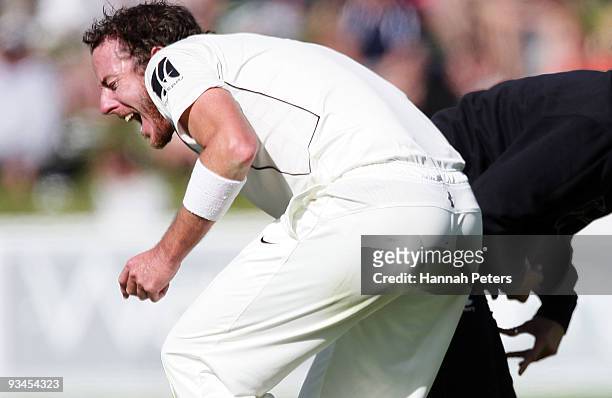 Iain O'Brien of New Zealand has his finger attended too by the team physio after injuring it fielding during day five of the First Test match between...