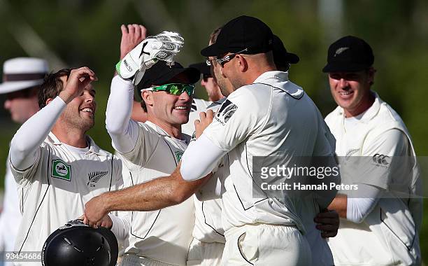 Daniel Vettori of New Zealand is embraced by Brendon McCullum as he celebrates the wicket of Mohammad Aamer of Pakistan to win the First Test match...