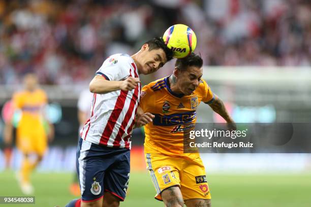 Michael Perez of Chivas jumps for the ball with Hugo Ayala of Tigres during the 12th round match between Chivas and Tigres UANL as part of the Torneo...