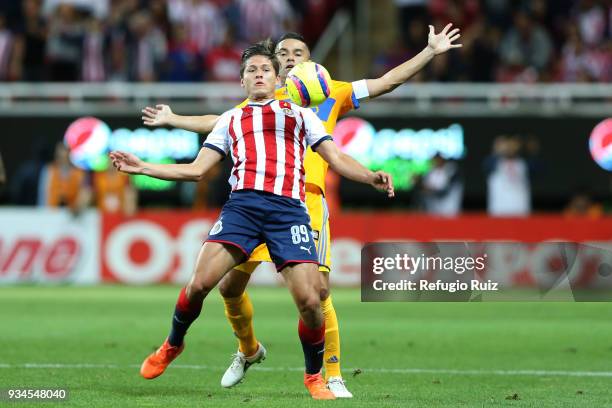 Jesus Godínez of Chivas fights for the ball with Juninho of Tigres during the 12th round match between Chivas and Tigres UANL as part of the Torneo...