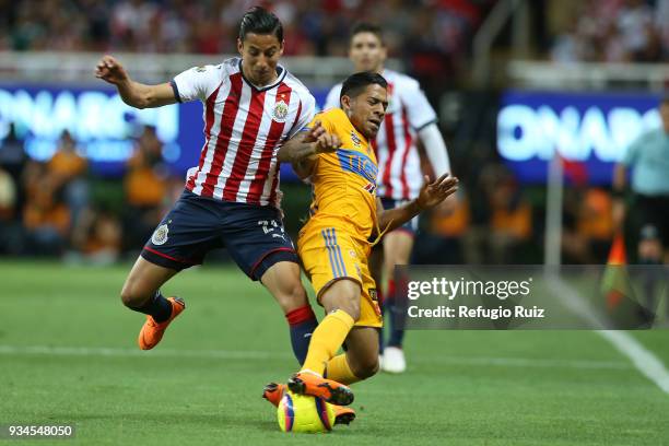 Carlos Cisneros of Chivas fights for the ball with Javier Aquino of Tigres during the 12th round match between Chivas and Tigres UANL as part of the...