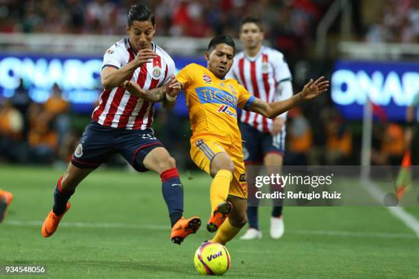 Carlos Cisneros of Chivas fights for the ball with Javier Aquino of Tigres during the 12th round match between Chivas and Tigres UANL as part of the...