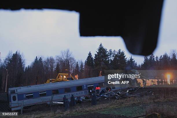 Experts inspect the damaged railway carriage near the village of Uglovka in Russia's Novgorod region on November 28 after a train derailed while...