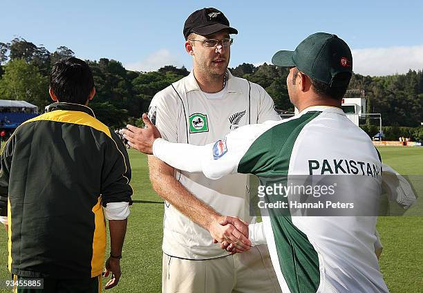 Daniel Vettori of New Zealand shakes hands with Khurram Manzoor of Pakistan after winning the First Test match on day five between New Zealand and...