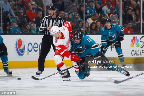 Luke Glendening of the Detroit Red Wings skates after the puck against Eric Fehr of the San Jose Sharks at SAP Center on March 12, 2018 in San Jose,...