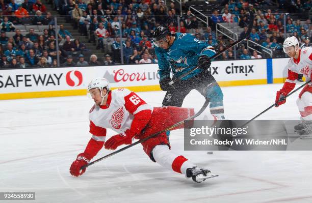 Danny DeKeyser of the Detroit Red Wings skates after the puck against Evander Kane of the San Jose Sharks at SAP Center on March 12, 2018 in San...