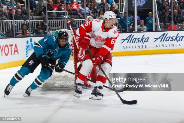 Danny DeKeyser of the Detroit Red Wings skates with the puck against Evander Kane of the San Jose Sharks at SAP Center on March 12, 2018 in San Jose,...