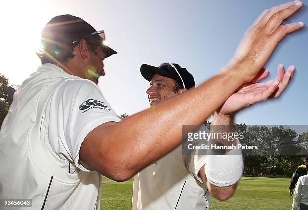 Daryl Tuffey celebrates with Shane Bond of New Zealand after winning on day five of the First Test match between New Zealand and Pakistan at the...
