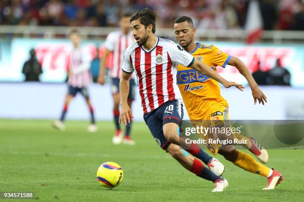 Rodolfo Pizarro of Chivas fights for the ball with Rafael de Souza of Tigres during the 12th round match between Chivas and Tigres UANL as part of...