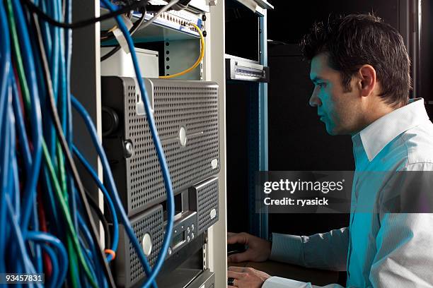 it technician in server room working at computer - datorport bildbanksfoton och bilder