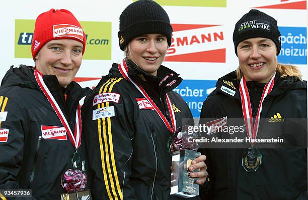 Competition winner Natalie Geisenberger of Germany and her team mates Tatjana Huefner as well as Anke Wischneweski smile during the flower ceremony...