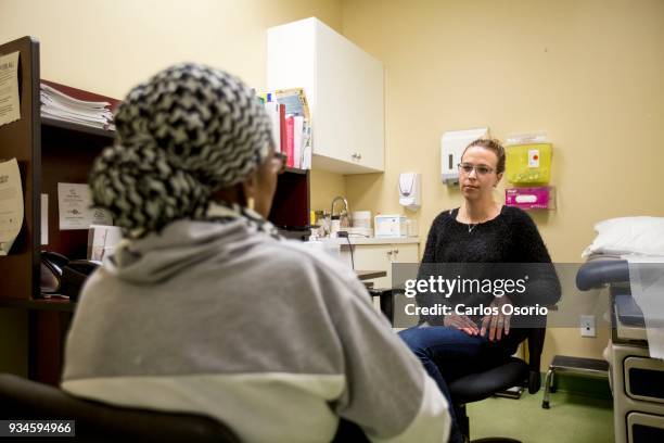 Health coach with the Health with Dignity program, Candace Crawford, speaks with client of the program, Patricia during her visit to the Access...