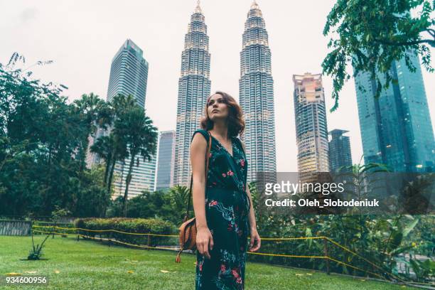 woman standing near    petronas tower - kuala lumpur stock pictures, royalty-free photos & images